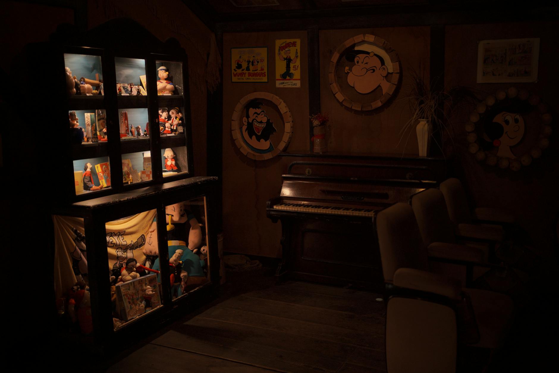 Cozy vintage room filled with Popeye memorabilia and an antique piano.
