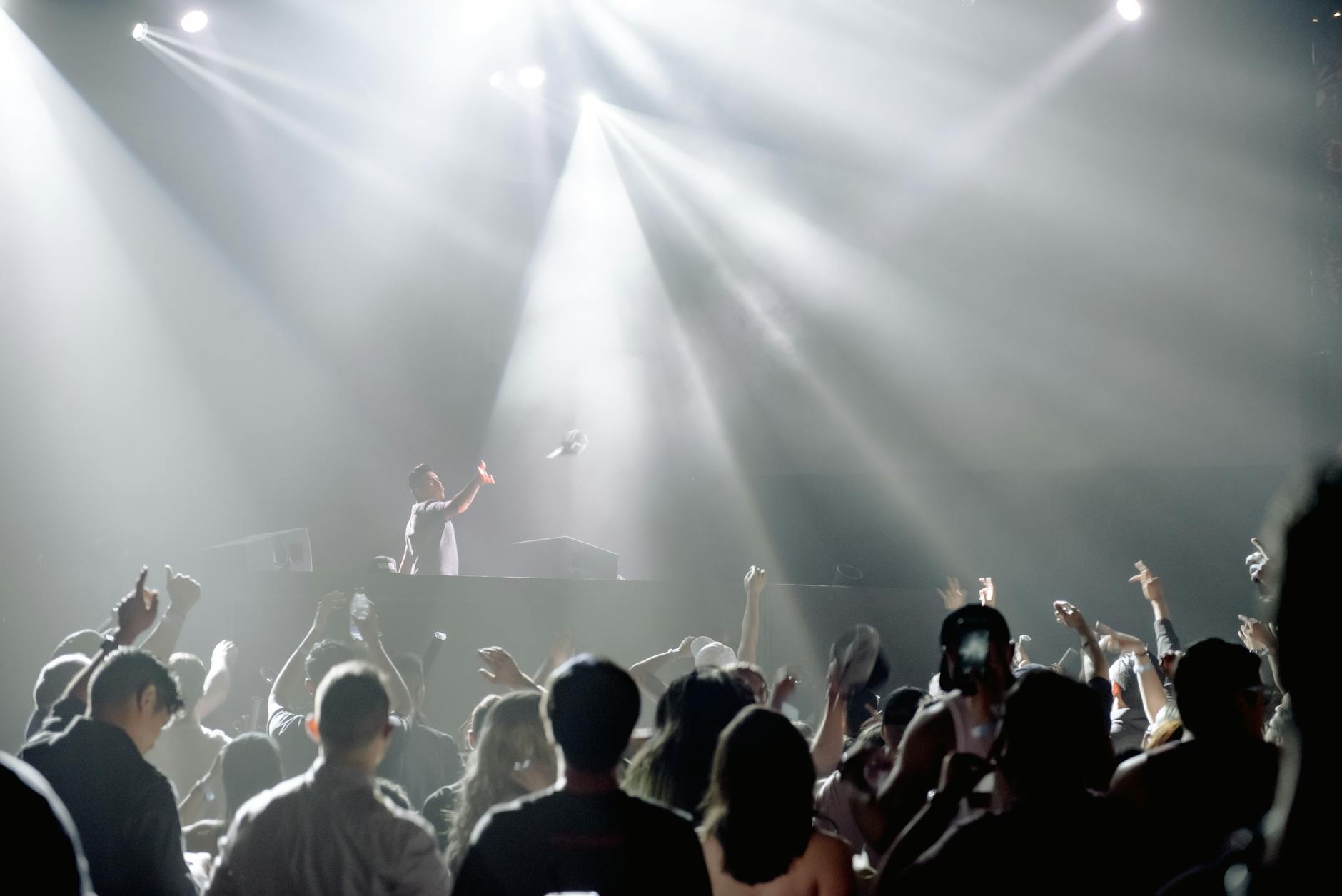 DJ performing in a lively nightclub with a crowd enjoying the vibrant atmosphere.