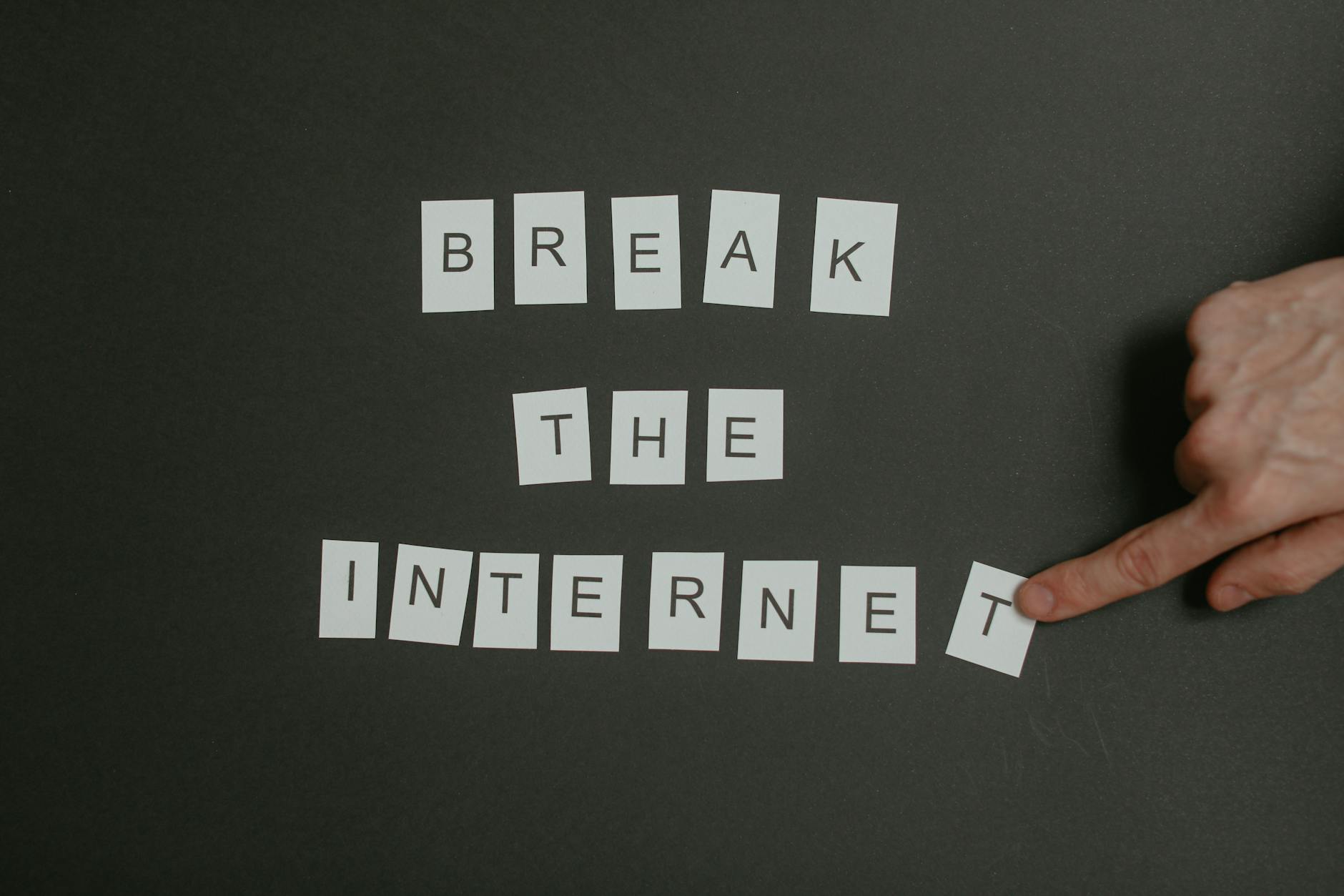 Textual phrase 'Break the Internet' arranged on a black background with a pointing hand.