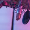 A close-up view of a microphone in a vibrant studio environment, ideal for podcasts and voice recording.