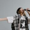 Energetic child singing on stage with microphone, expressing passion.