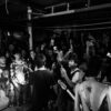 Black and white photo capturing a dynamic live band performing to an enthusiastic crowd.