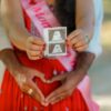A joyful couple holding an ultrasound photo, celebrating pregnancy outdoors.