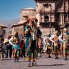 Colorful dancers in traditional costumes parade through Cusco, showcasing rich cultural heritage.