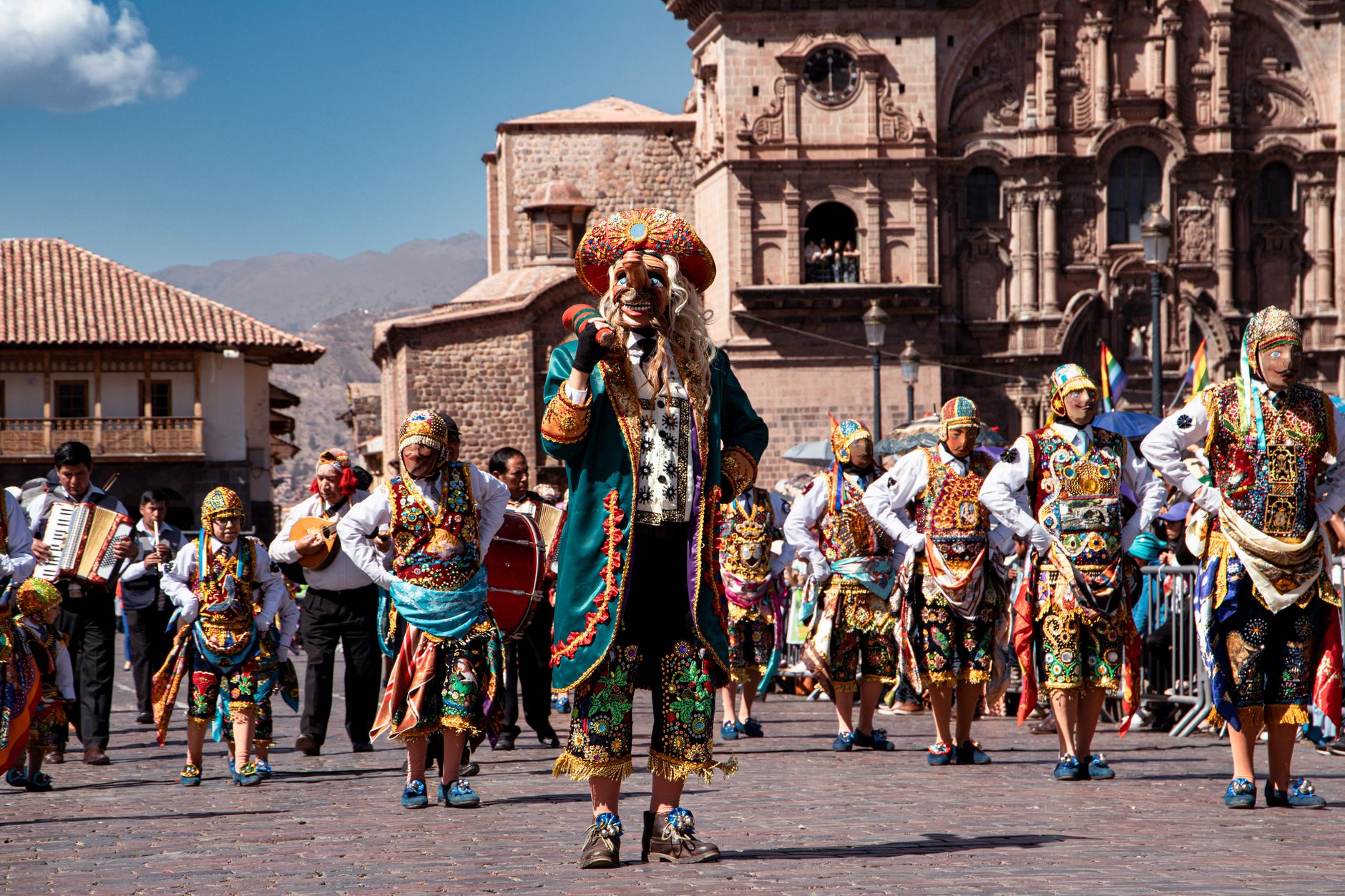 Colorful dancers in traditional costumes parade through Cusco, showcasing rich cultural heritage.