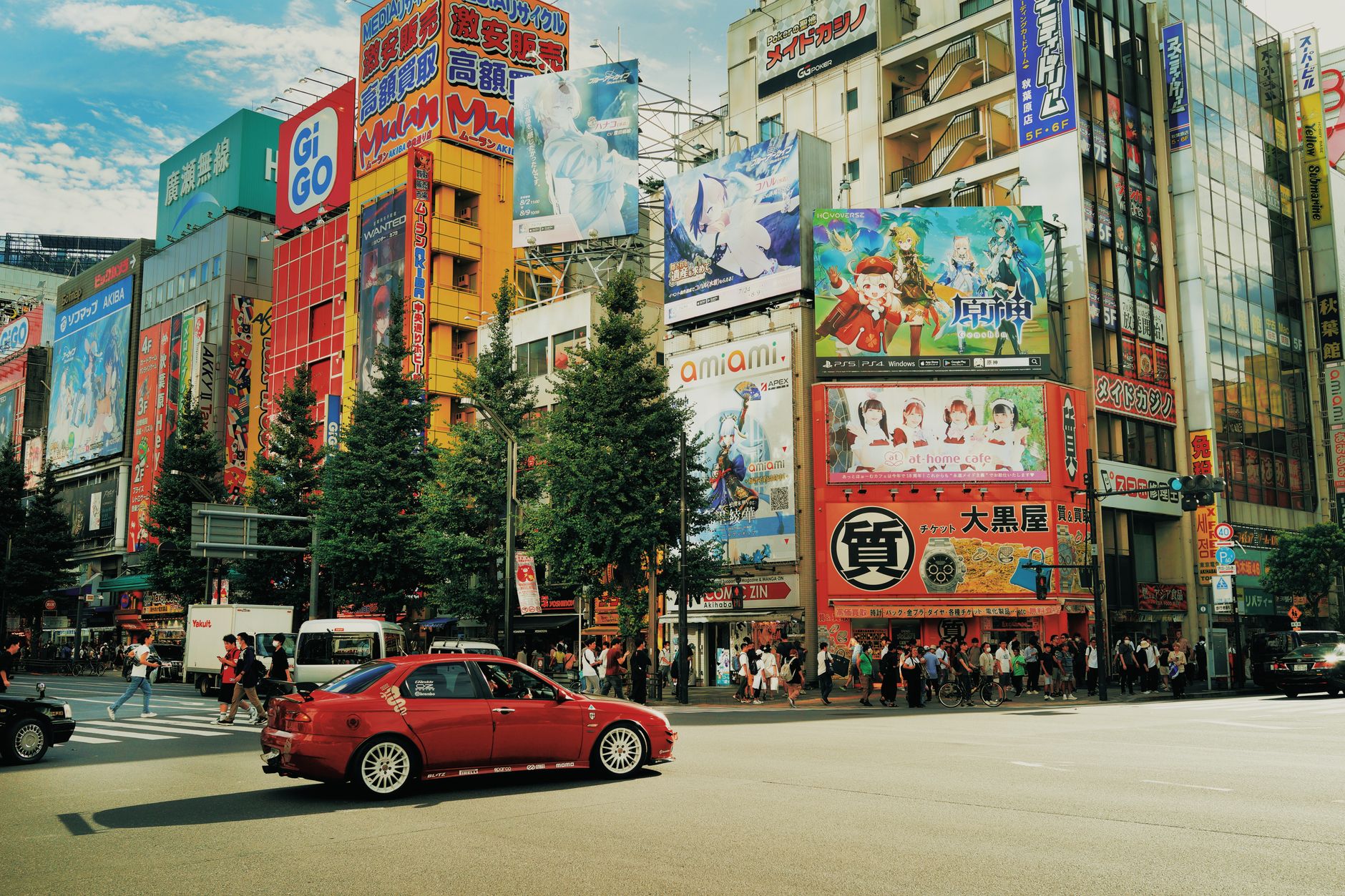 Street view of Akihabara, Tokyo with colorful billboards and bustling activity.