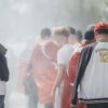 Group of sports fans with Turkish flags and smoke outdoors, showing enthusiasm.