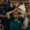 Energetic crowd of football fans showing emotions during a live match.