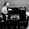 Camera capturing an indoor interview scene, in focus with a blurred background.