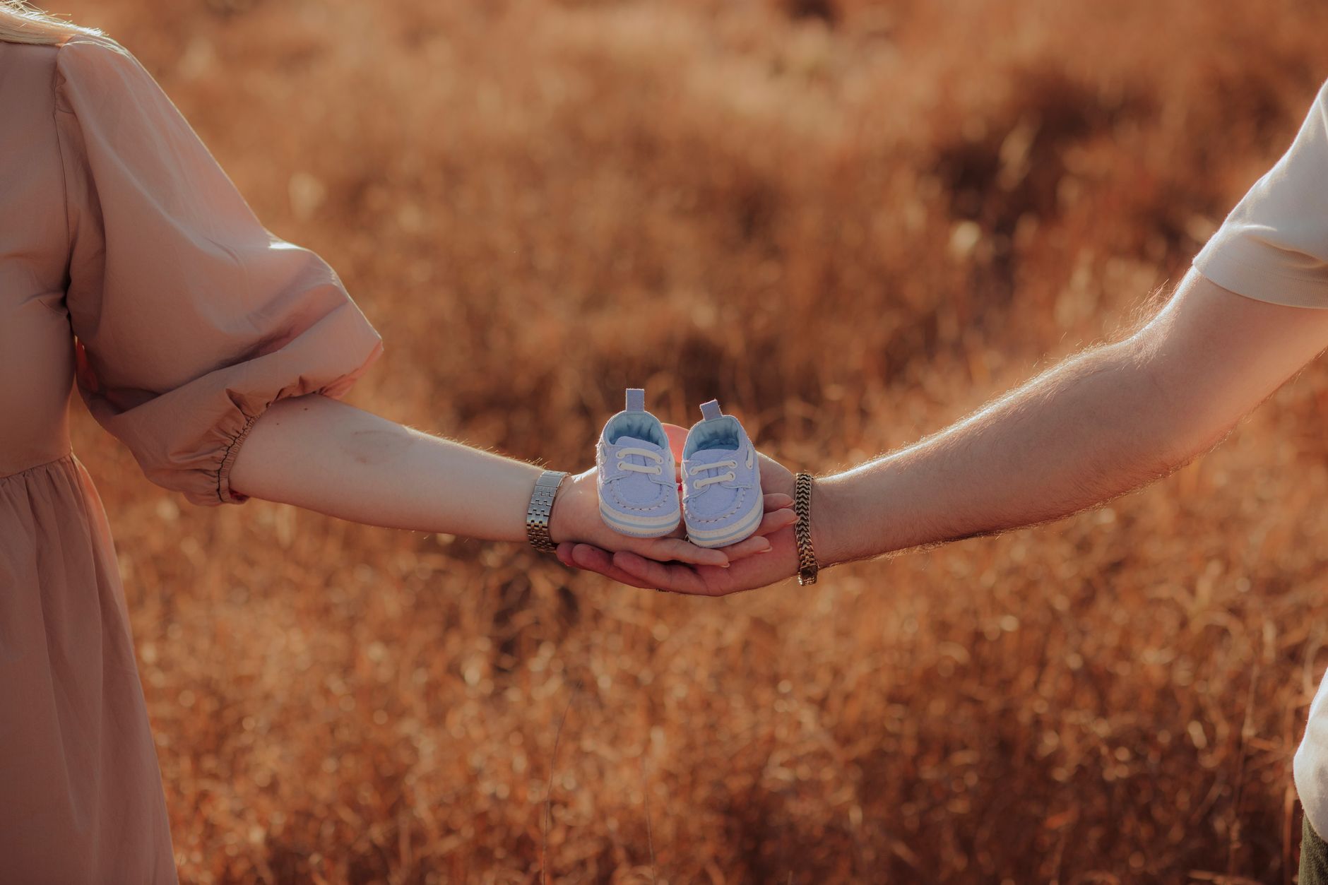 Heartwarming photo of parents holding baby shoes symbolizing a new journey in Sinaloa, Mexico.