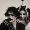Two adults in harlequin costume and mime makeup, capturing a classic theatrical scene