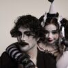 Two adults in harlequin costume and mime makeup, capturing a classic theatrical scene