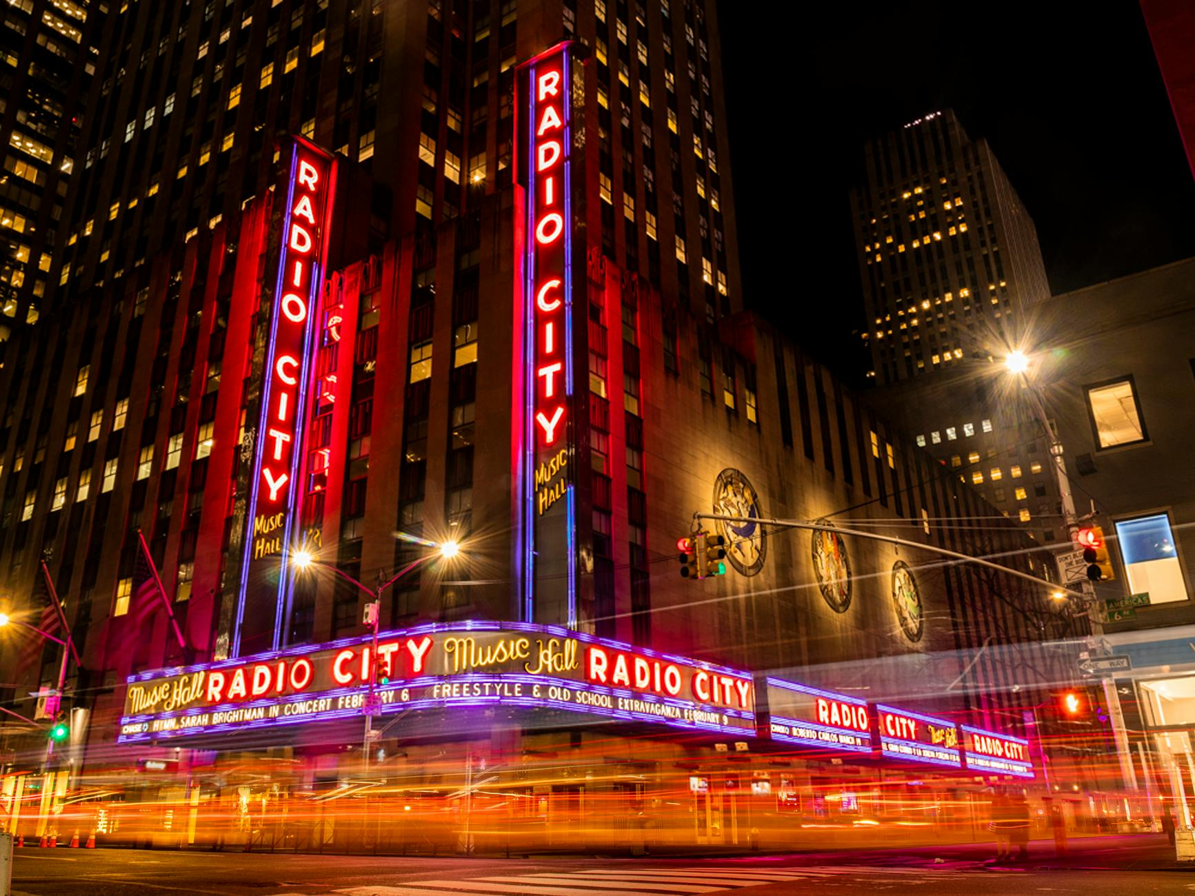 Vibrant night scene of Radio City Music Hall in NYC's Rockefeller Center.