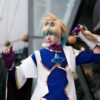 Dynamic cosplay portrait of a sci-fi character with colorful costume and playful pose outdoors.