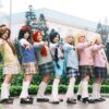A vibrant group of cosplayers posing outdoors in anime-inspired costumes, showcasing colorful outfits and playful poses.