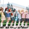 A group of six people in anime-themed cosplay posing outdoors. Energetic and colorful.