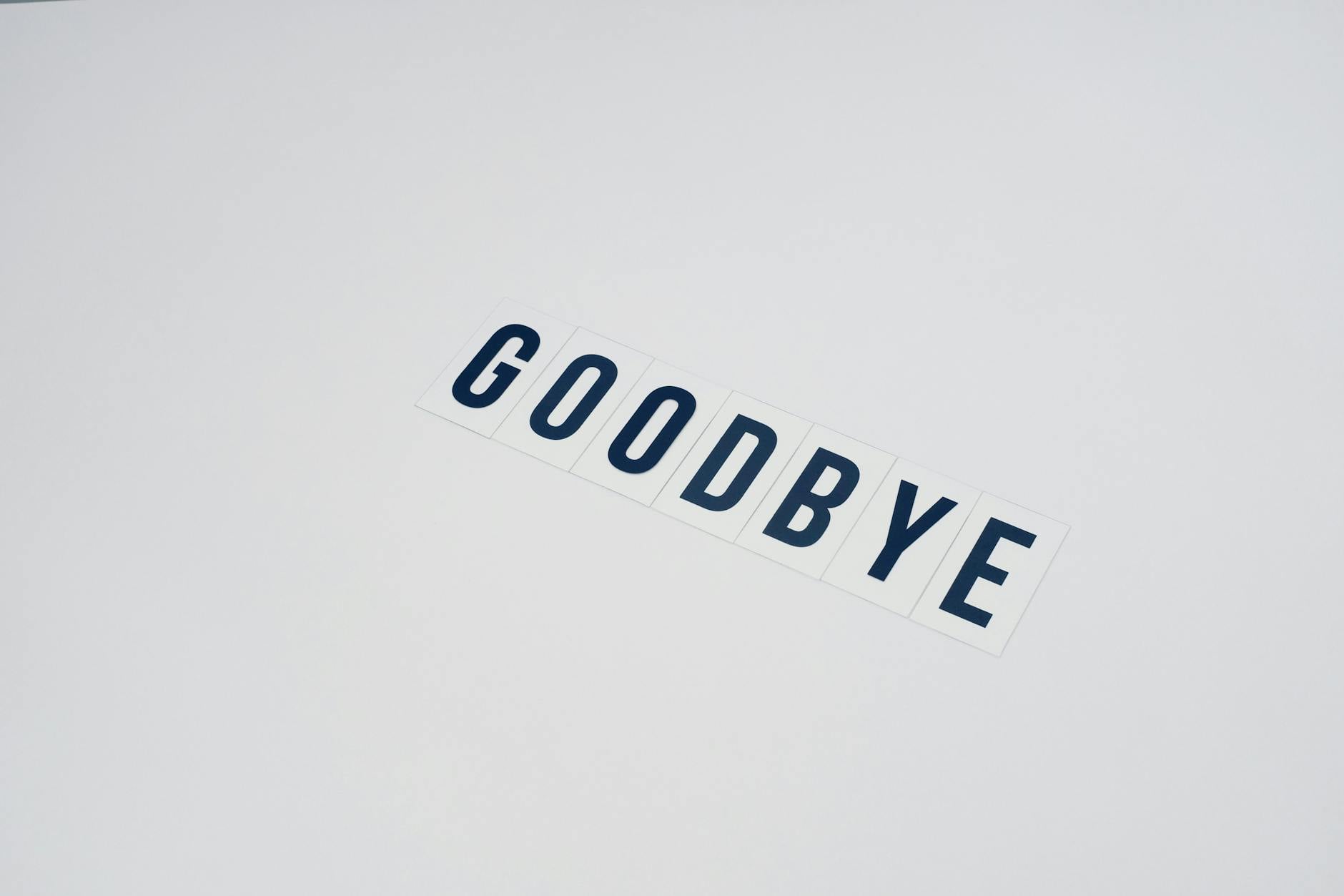 Simple typography displaying the word goodbye on a clean white background, offering ample copy space.