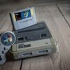 From above of aged video game console with cassette and controller with colorful buttons on wooden surface