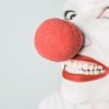 Bright close-up of a clown's face with red nose and makeup, showcasing humor and joy.