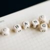 Close-up of letter dice spelling 'change' on a grid notepad, symbolizing transformation.