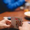 Close-up of a person holding playing cards during a poker game, focused on strategy and excitement.