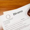 Close-up of a divorce document and wedding ring on a lawyer's desk.