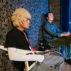 Two young musicians in a studio, featuring an electric guitar and artistic vibe.