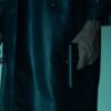Close-up of an unrecognizable person holding a pistol, creating a mysterious and suspenseful mood.