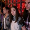 A group of diverse young adults on a film set, engaging in a creative production indoors.
