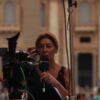 Journalist reporting live from Vatican City, capturing the essence of urban broadcast journalism.