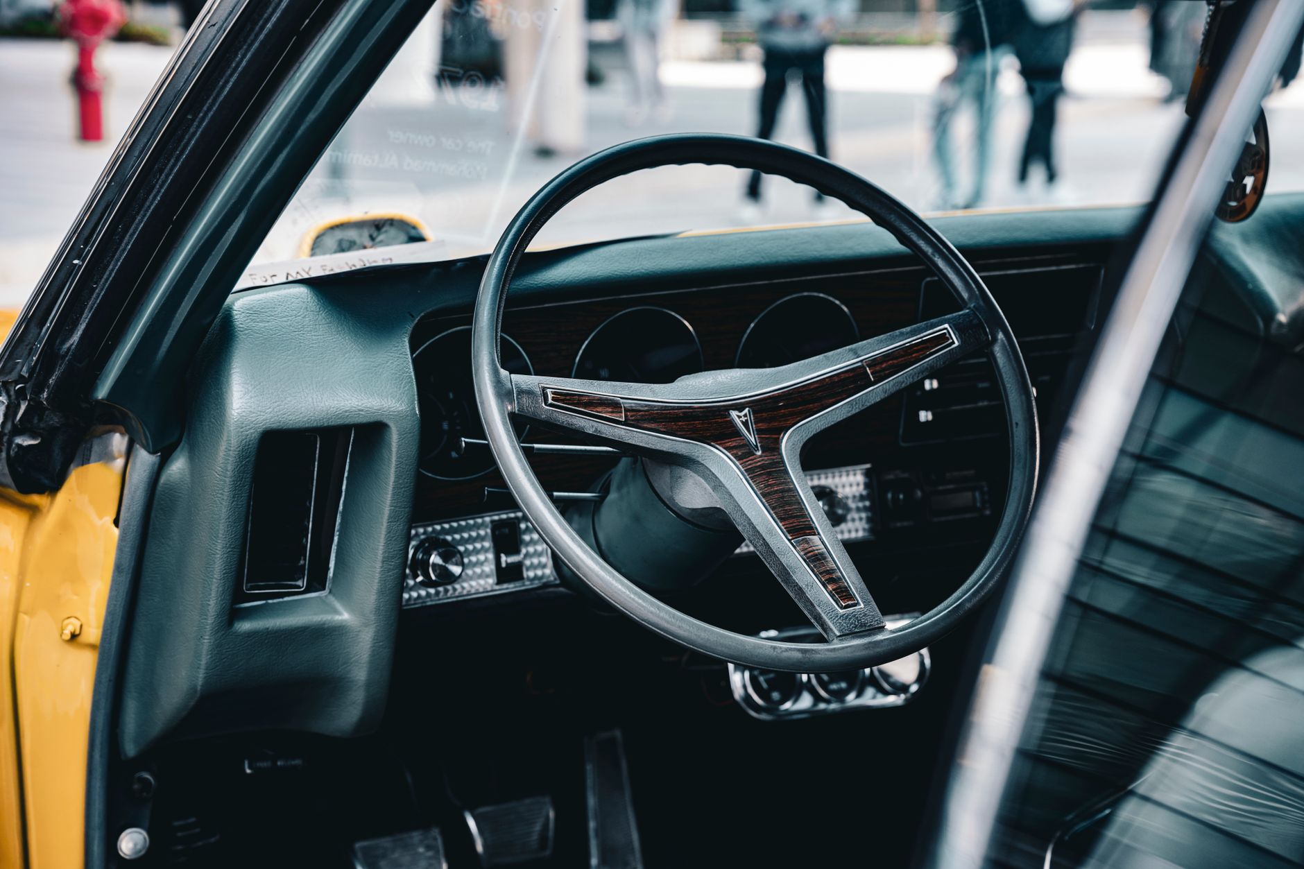 Close-up of a classic Pontiac GTO steering wheel in Kuwait City, capturing retro automotive style.