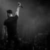 Energetic musician with microphone, entertaining crowd at live concert.