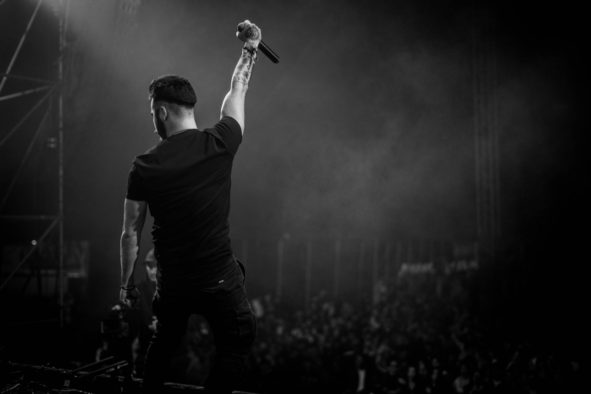Energetic musician with microphone, entertaining crowd at live concert.