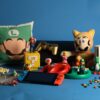 A vibrant assortment of gaming collectibles, including Nintendo figures, consoles, and candy on a blue background.