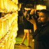 Man photographing glowing Mitama lanterns at a Japanese festival, showcasing cultural traditions and night ambiance.