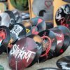 Collection of artistic vinyl records featuring iconic band designs on display at market.