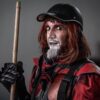 A dramatic street performer in a striking red and black costume with makeup.