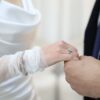 A close-up shot of a bride and groom exchanging wedding rings, symbolizing eternal love.