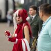 Cosplayer in striking red and white outfit at an outdoor anime event in Costa Rica.