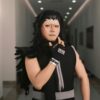 Cosplayer dressed as a dramatic anime character poses confidently in an indoor corridor.