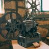 Classic vintage film projector displayed in a rustic indoor setting. Perfect for cinema enthusiasts.