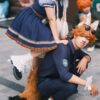 Cosplayers dressed uniquely pose joyfully outdoors. Explore creativity and cosplay culture.
