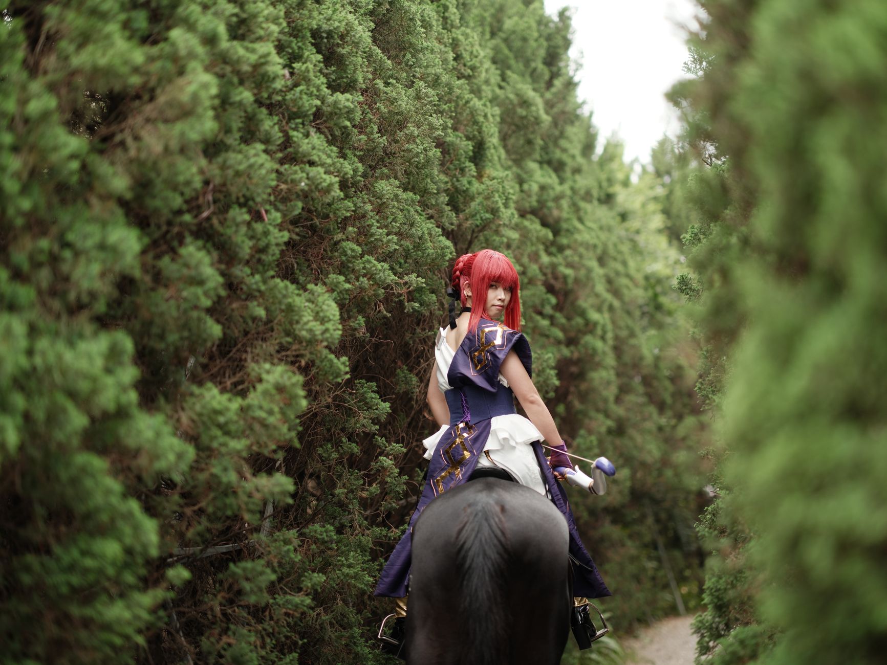 A person in cosplay riding a horse through a lush, green forest path. Captivating and enchanting.
