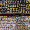 Vibrant handcrafted ceramic fridge magnets featuring animals, characters, and teapots on market display.