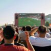 Crowd watching a soccer game on a large screen outdoors in Istanbul, Türkiye.
