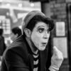 A captivating black and white portrait of a mime artist performing indoors, showcasing expressive facial expressions and makeup.
