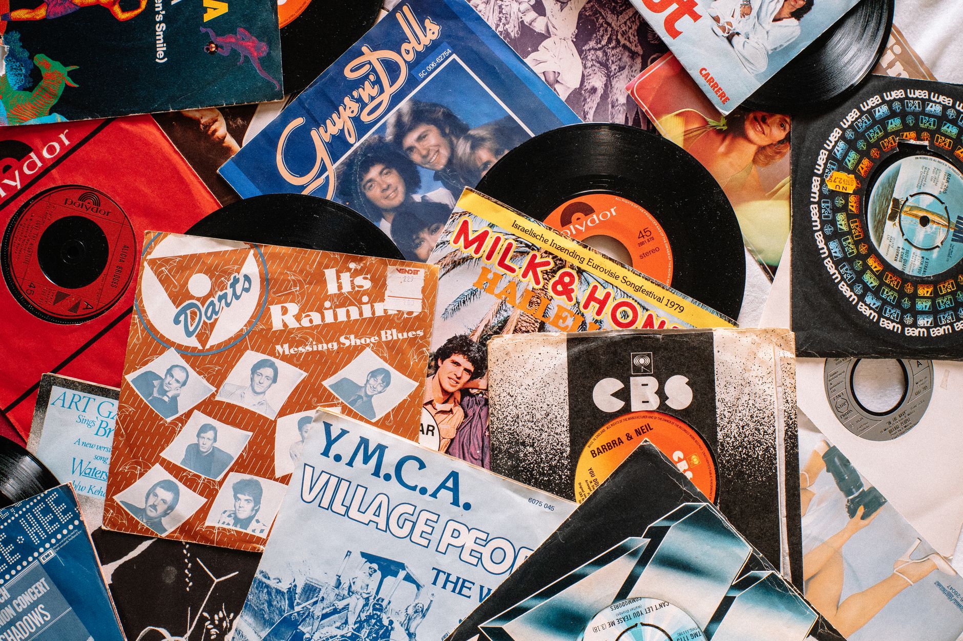Top view composition of old fashioned vinyl discs in colorful packs heaped on table