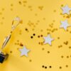 Shiny golden trophy and stars on a vibrant yellow background, symbolizing success and victory.