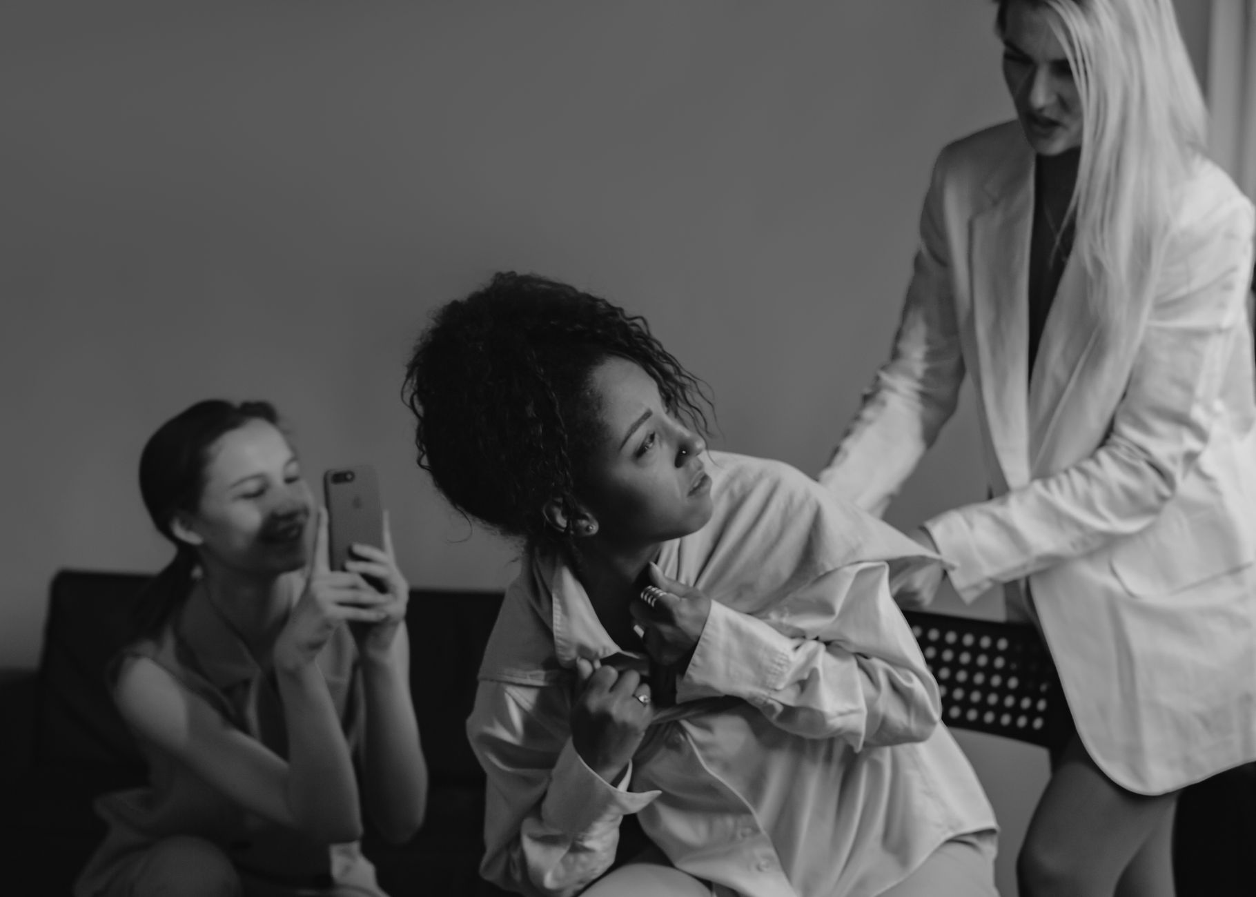 A dramatic black and white photograph capturing conflict and tension among diverse women.