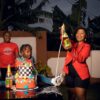 A joyful birthday celebration outdoors with family, featuring a colorful cake and sparkling drinks.
